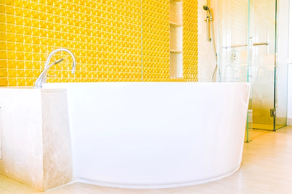 Cerámica baño Valencia con revestimiento cerámico amarillo y bañera moderna
