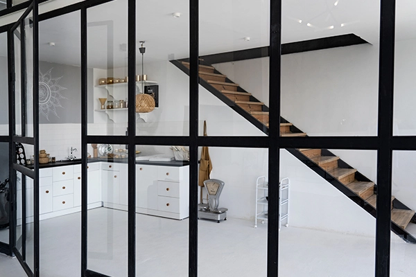 Mamparas a medida Valencia: cerramiento de cristal con perfilería negra para separar ambientes.