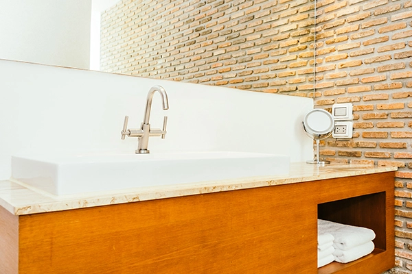 Muebles de baño Valencia: mueble de madera con lavabo y grifería moderna en baño.